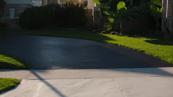 A driveway immediately after sealcoating, uniform matte black with a sharp edge